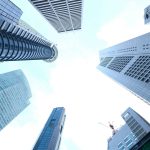 A striking upward view of various skyscrapers in an urban setting against a clear sky. — The Alluring Excitement of Nuru Mass