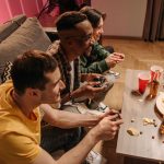 Group of friends playing video games and enjoying snacks indoors. — The Top 10 Must-Play Online Slot Games This Year